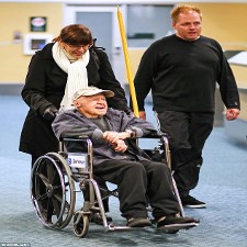 Couple Pushing Man in Wheelchair