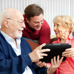 Older Parents and Son Looking At Tablet